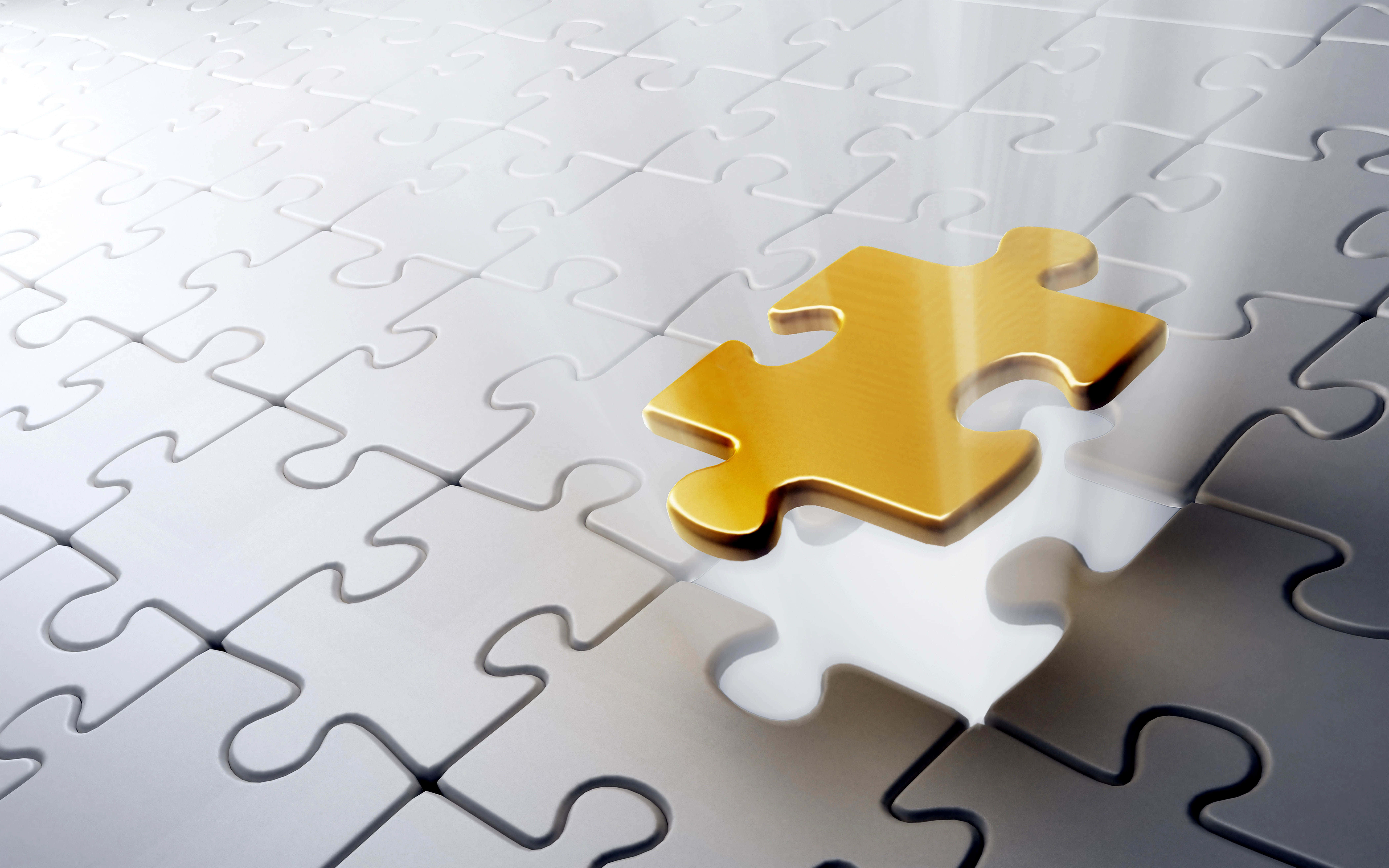 Puzzle Games 桌布 壁紙 — 一塊閃閃發光的金色拼圖塊漂浮在銀色拼圖網格上方，光線柔和。