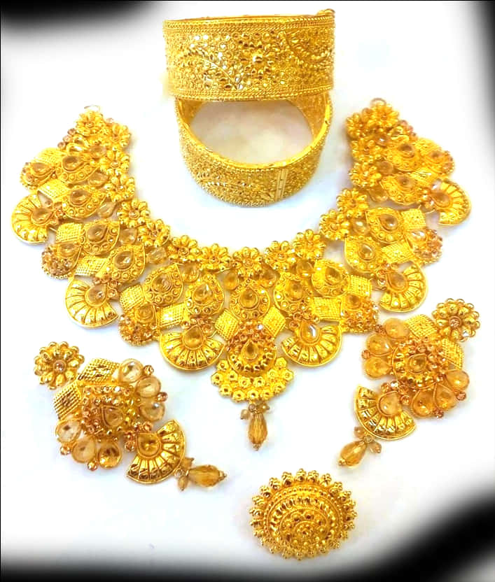 Indian Jewellery 桌布 壁紙 — 一套奢華的金色珠寶套裝，帶有精緻的鏤空工藝和琥珀寶石，擺放在白色表面上。