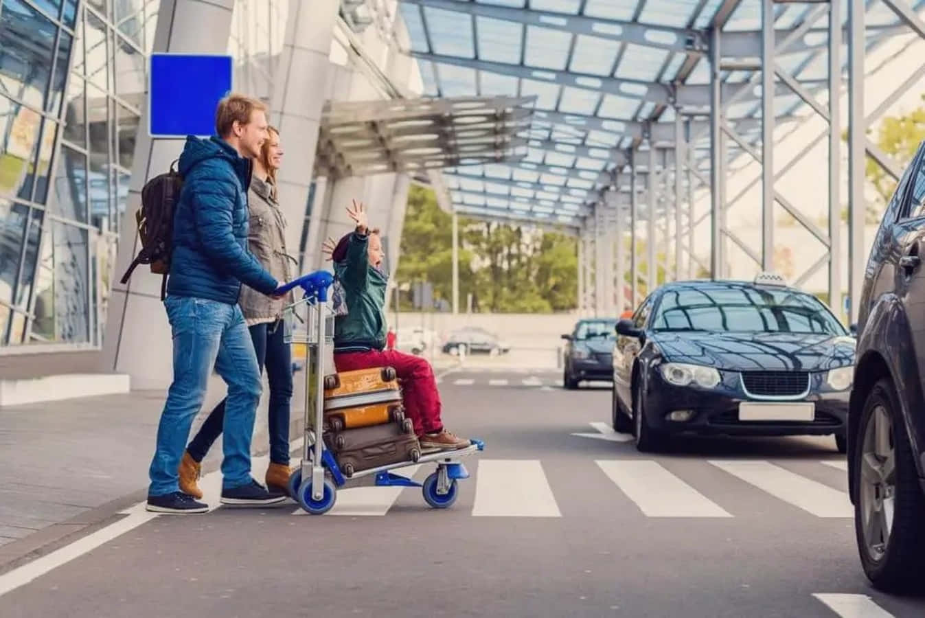 Traveling 桌布 壁紙 — 一家人在機場航廈拖著行李步行，附近有計程車等候。