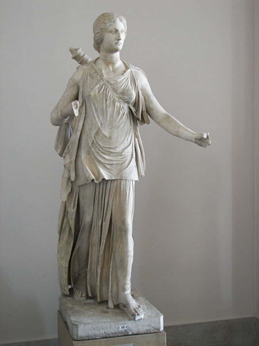 greek 桌布 壁紙 — 一尊古典大理石女性雕像，身披垂褶布料，優雅地立於博物館環境中的基座上。