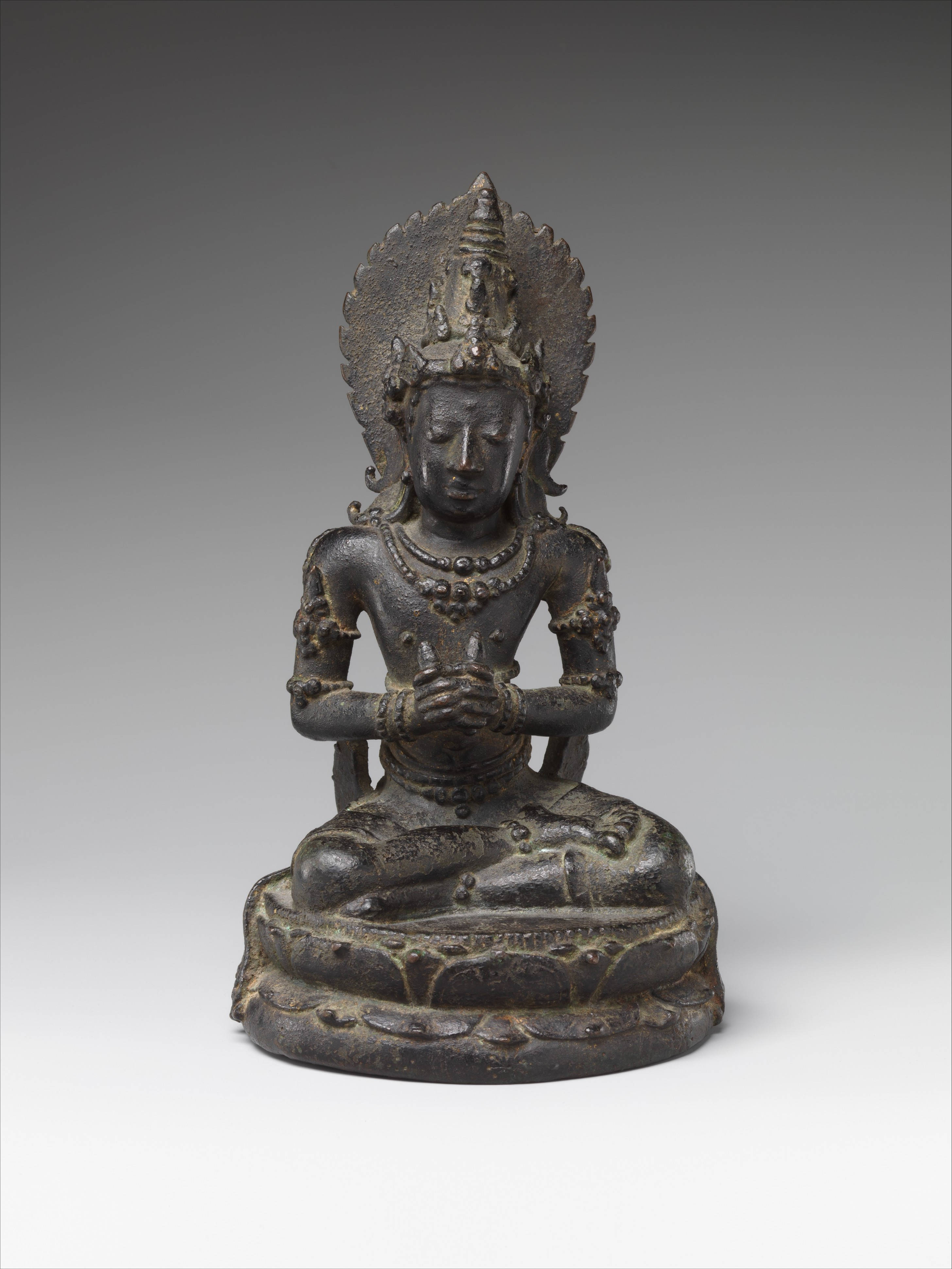 Statue Aesthetic 桌布 壁紙 — 一尊古老的青銅佛像雙手合十，靜靜地冥想，飾有精緻的珠寶和光環，背景為中性工作室背景。