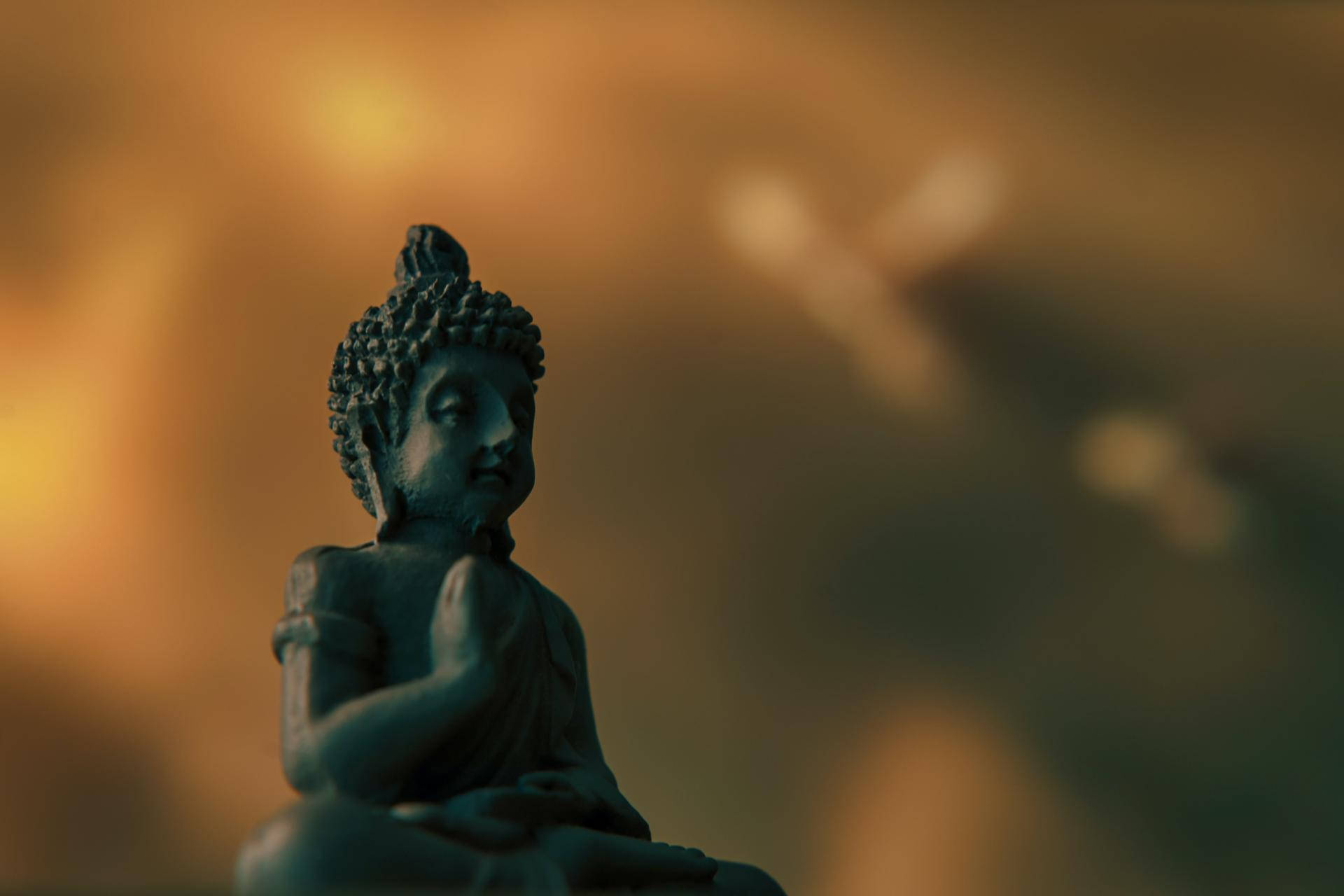 Holistic 桌布 壁紙 — 一尊寧靜的佛像在溫暖的金色散景背景下打坐冥想。