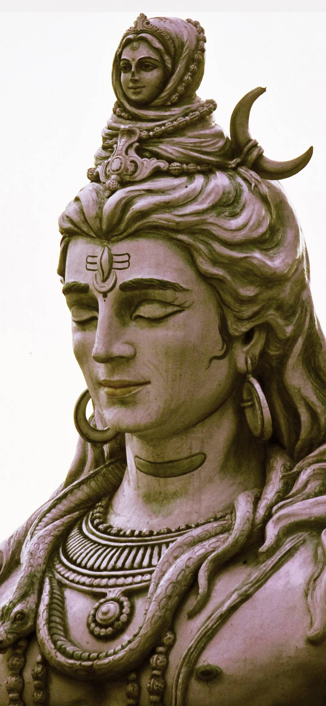 shiva iPhone 桌布 壁紙 — 一尊寧靜的濕婆石像，閉著眼睛，頭頂裝飾著新月和女神。