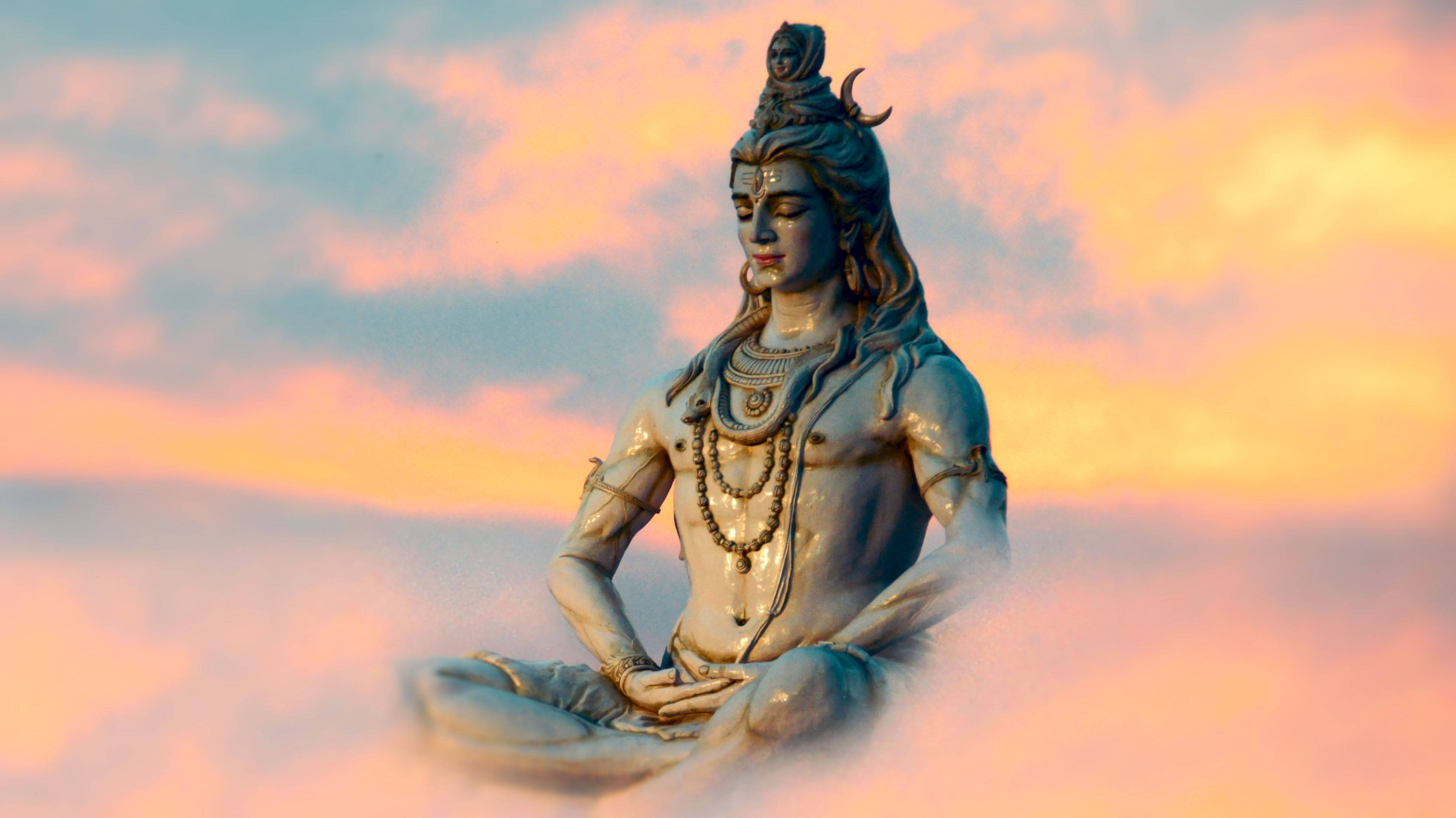 bholenath HD 桌布 壁紙 — 一尊寧靜的濕婆雕像在雲端上冥想，背景是充滿粉紅色和橙色色調的 vibrant 日落天空。