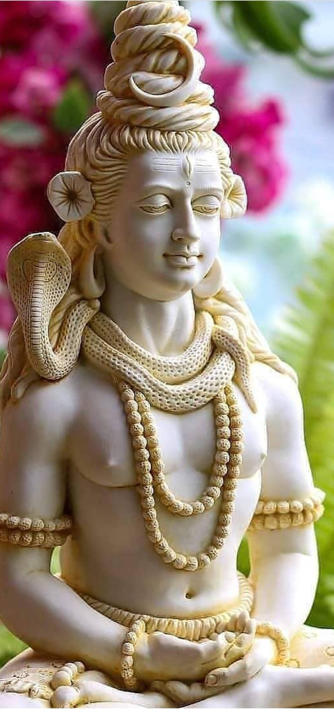hindu iPhone 桌布 壁紙 — 一尊寧靜的白色石雕濕婆神像，頸上纏繞著眼鏡蛇，頭髮上有新月，背景是柔和的花卉。