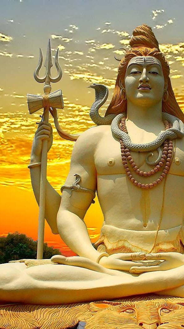 Mahadev Full HD 桌布 壁紙 — 一尊寧靜的石像，主神濕婆在金色夕陽天空下冥想，手持三叉戟、眼鏡蛇和念珠。