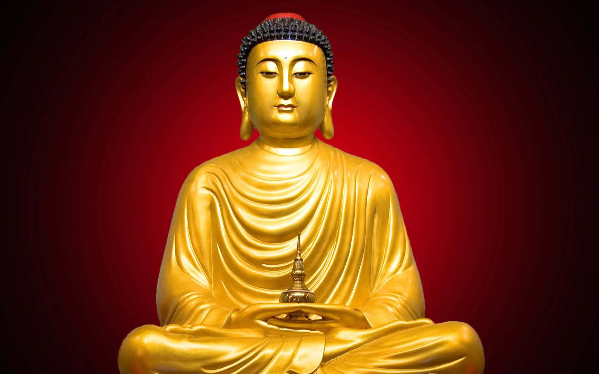 Gautama Buddha 桌布 壁紙 — 一尊寧靜的金色佛像在深紅色漸變背景前冥想打坐。