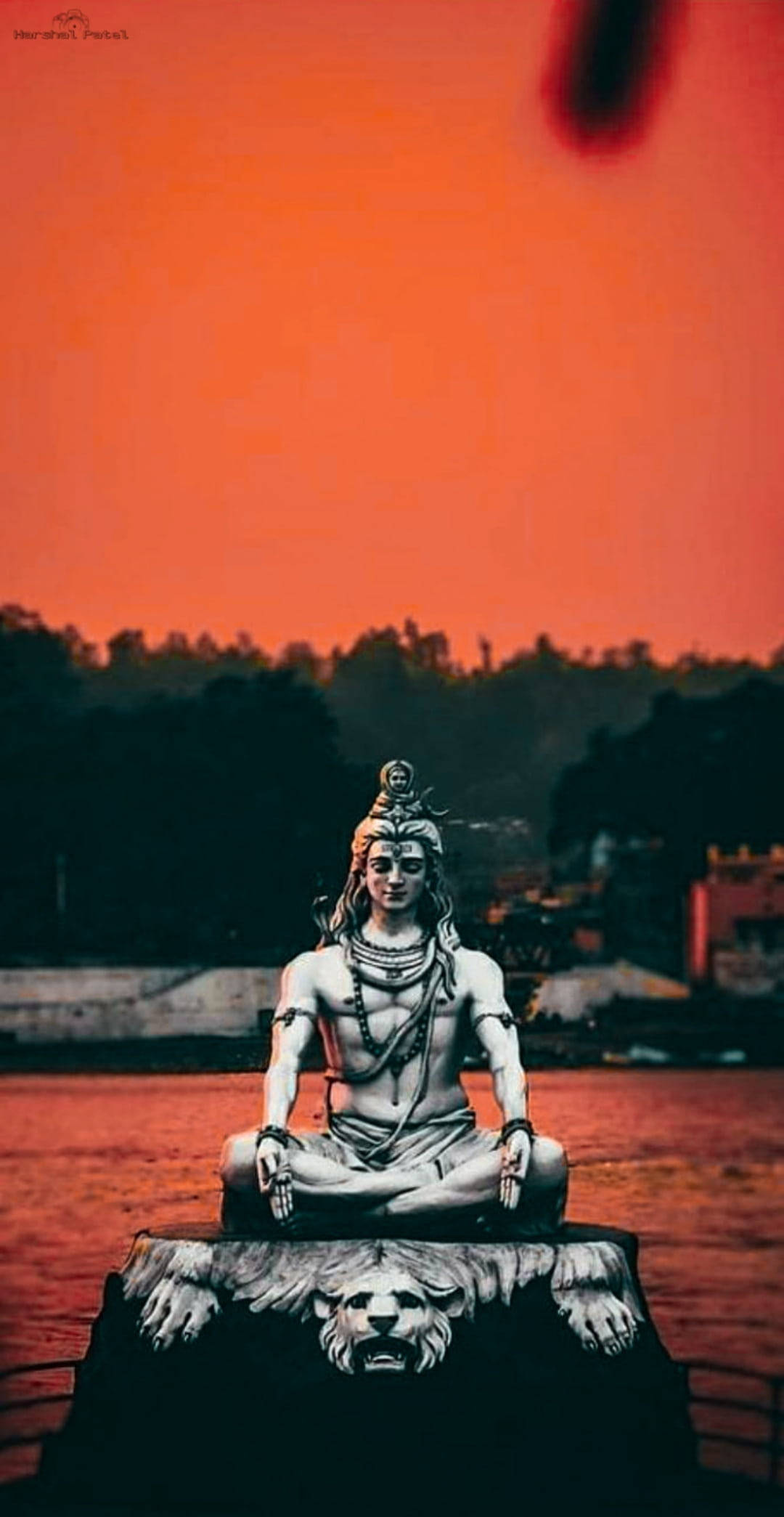 Mahadev Full HD 桌布 壁紙 — 一尊寧靜的銀色濕婆神像在獅頭底座上冥想，背景是火紅的橙色日落天空。