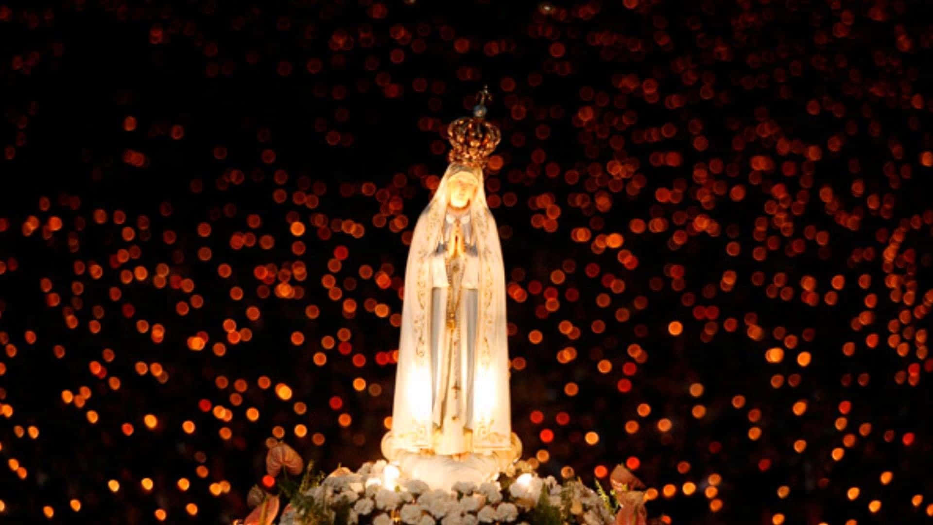Catholic Desktop 桌布 壁紙 — 一尊發光的聖母瑪利亞雕像，頭戴皇冠，身披白布，在溫暖發光的散景燈光背景下寧靜地站立。