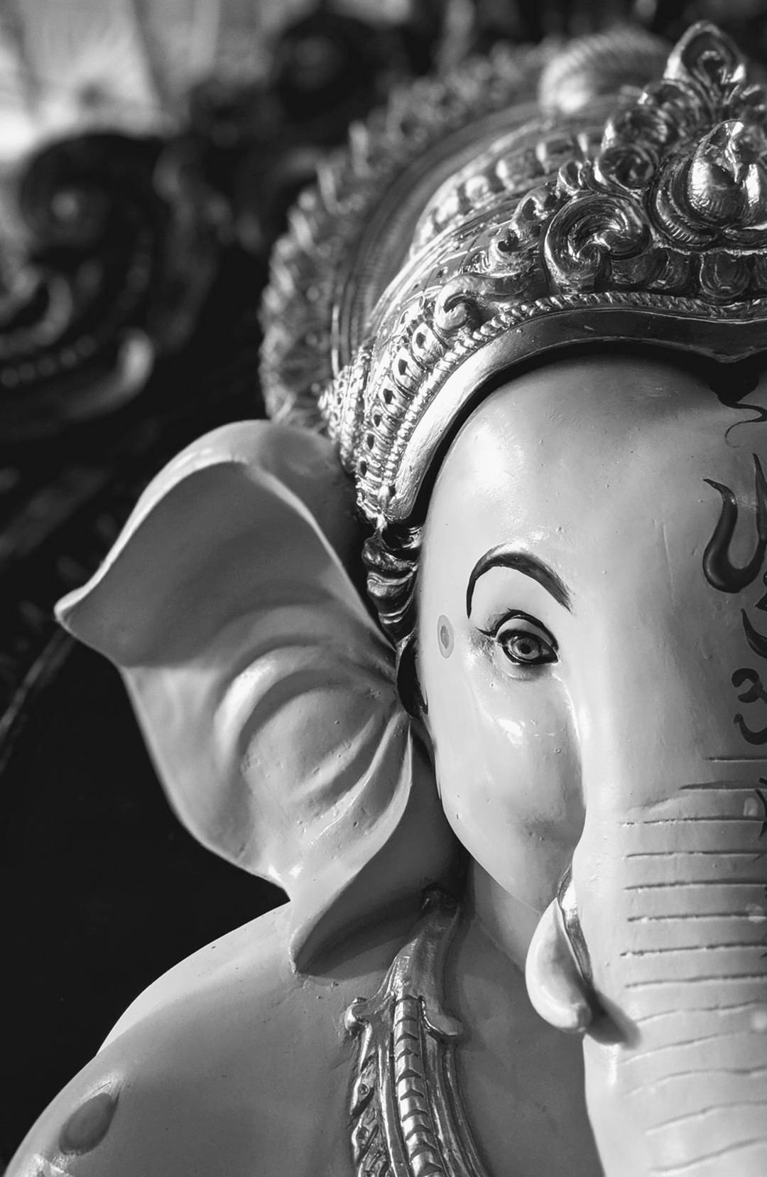 Ganesh 桌布 壁紙 — 一尊細節豐富的象神雕像黑白特寫照片，飾有華麗頭冠和大耳朵。