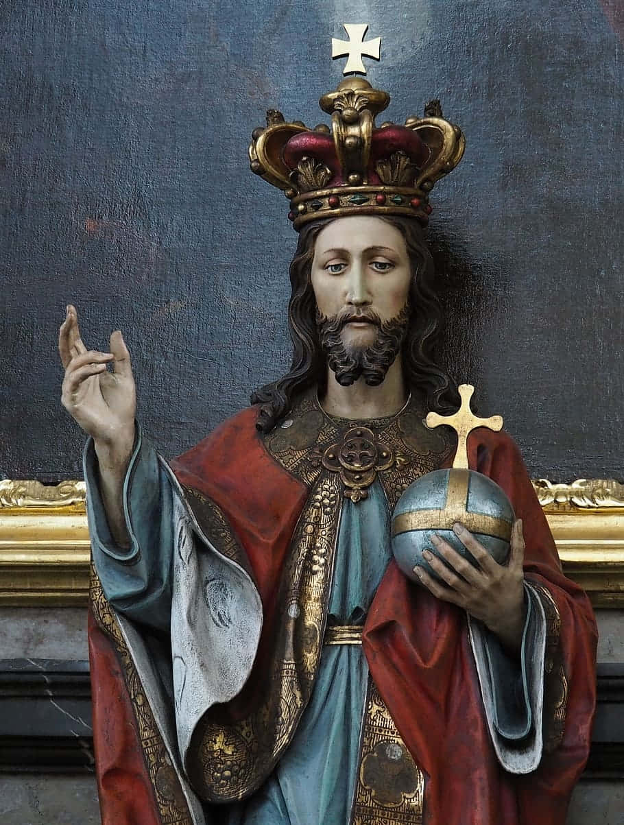 Jesus Is King 桌布 壁紙 — 一尊莊嚴的耶穌基督雕像，戴著鑲有寶石的王冠，手持頂端有十字架的地球儀。
