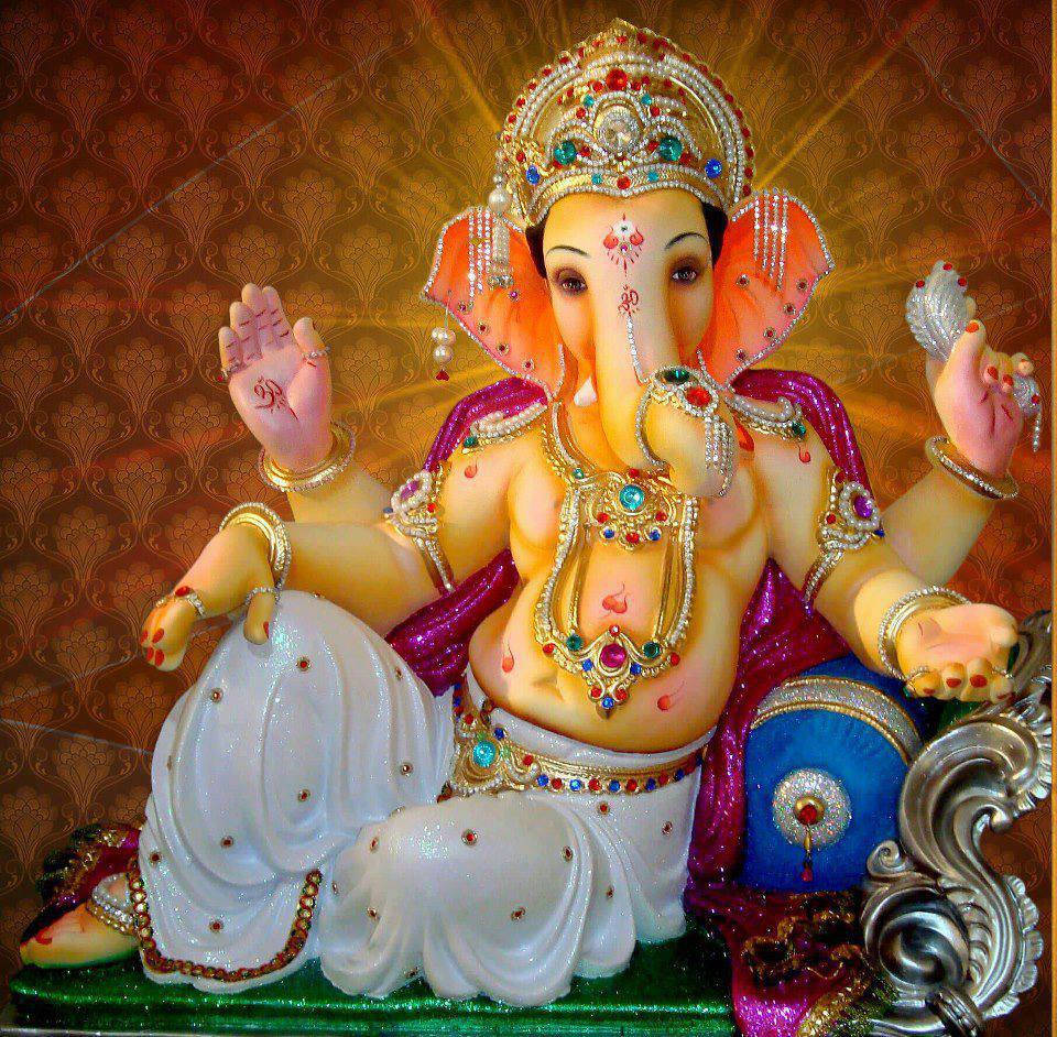 ganpati HD 桌布 壁紙 — 一尊裝飾華麗的金色象神雕像，端坐在鑲滿寶石的寶座上，背景是帶有圖案的金色背景。