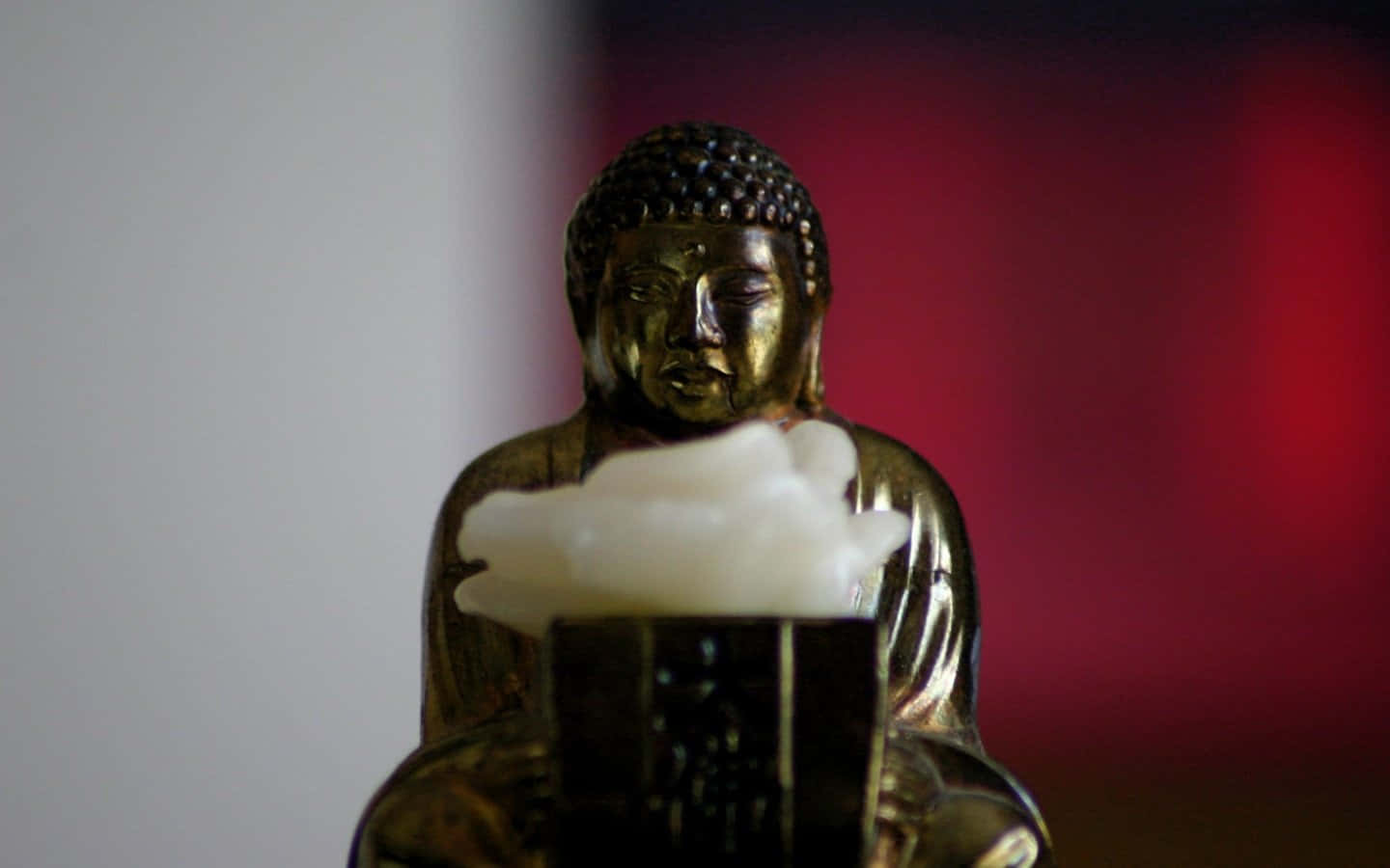 佛陀 桌布 壁紙 — 一尊金色佛像在模糊的紅白背景前手持一個白色雲狀物體。