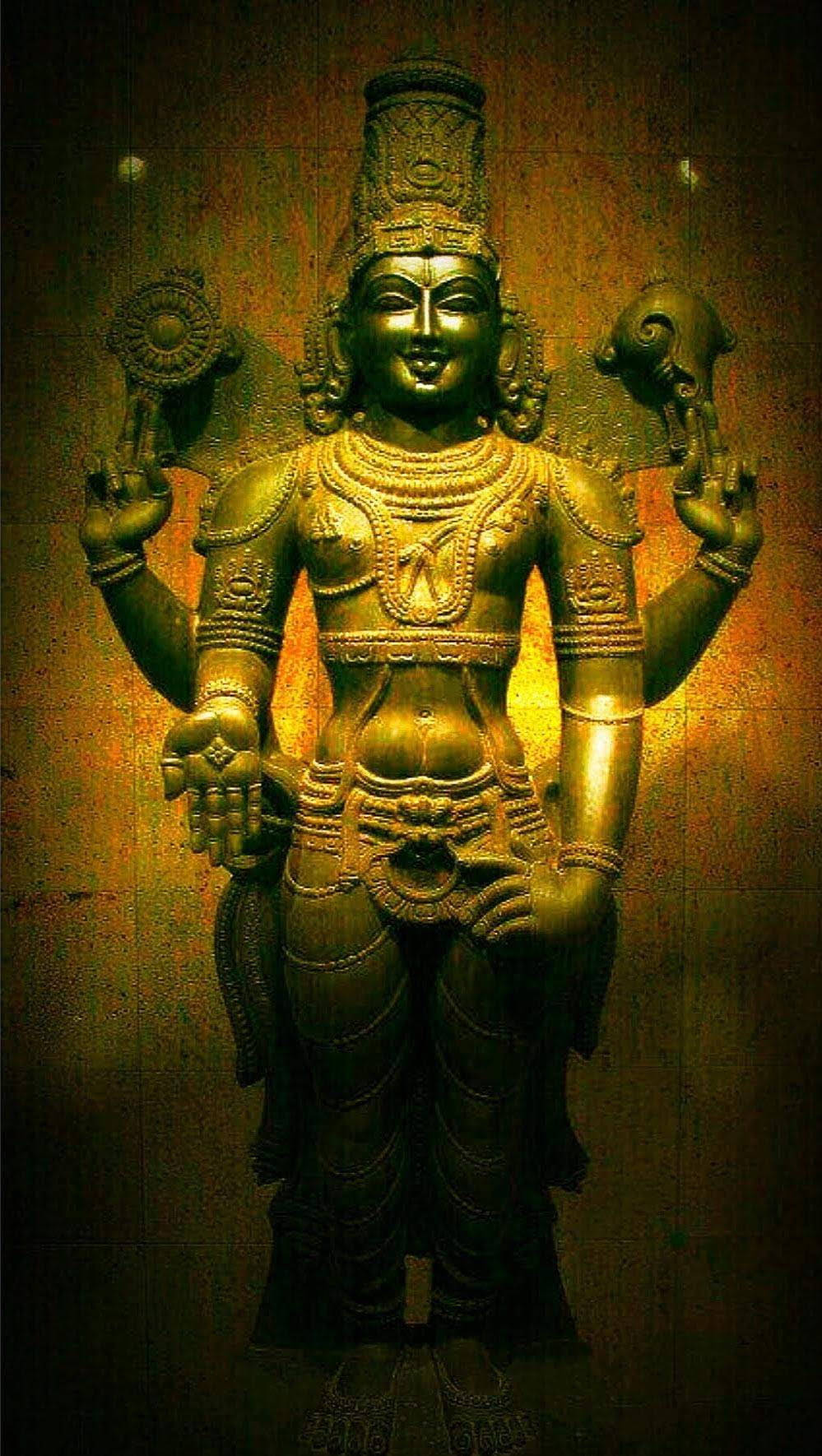 hindu iPhone 桌布 壁紙 — 一尊金色青銅多臂印度教神像，飾有精緻珠寶，手持象徵性物品，背景為溫暖的紋理牆壁。