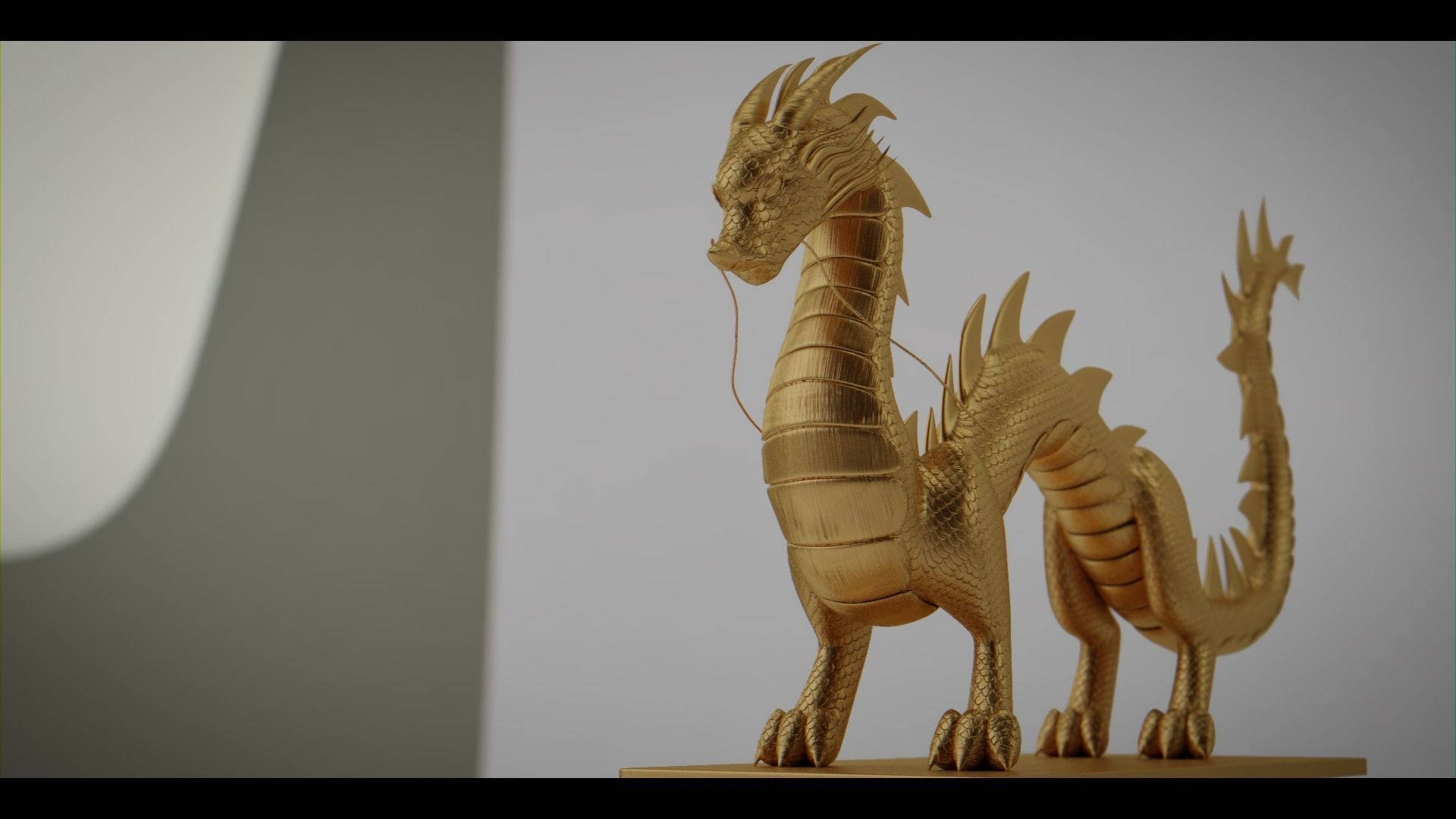Gold Dragon 桌布 壁紙 — 一尊金色龍雕塑，帶有精緻的鱗片和尖刺狀的鰭，在極簡灰色背景前蓄勢待發。