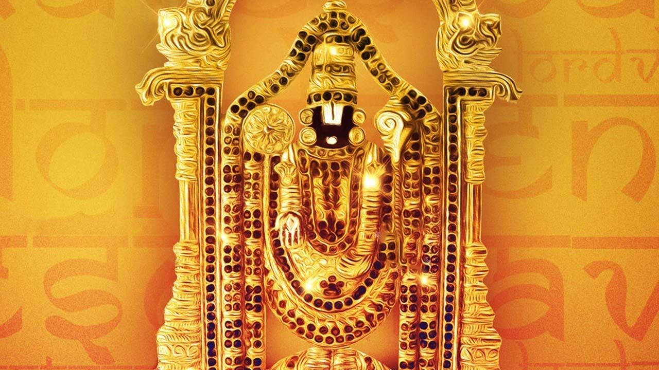 Venkateswara 桌布 壁紙 — 一尊閃耀的金色神像，飾有精緻雕刻和發光點綴，置於帶有模糊梵文的溫暖橙色背景上。
