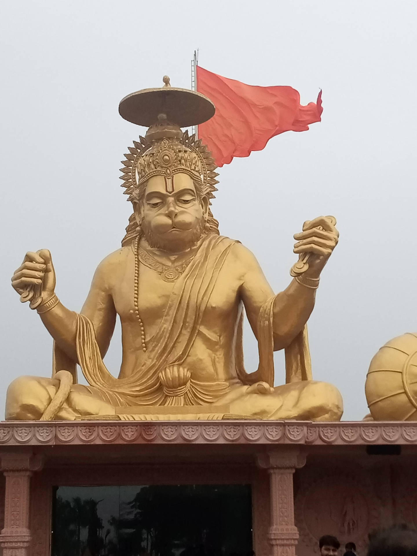 金色哈努曼雕像坐在寺廟平台上，紅旗飄揚。 — 萬福瑪哈拉賜福高清壁紙 壁紙