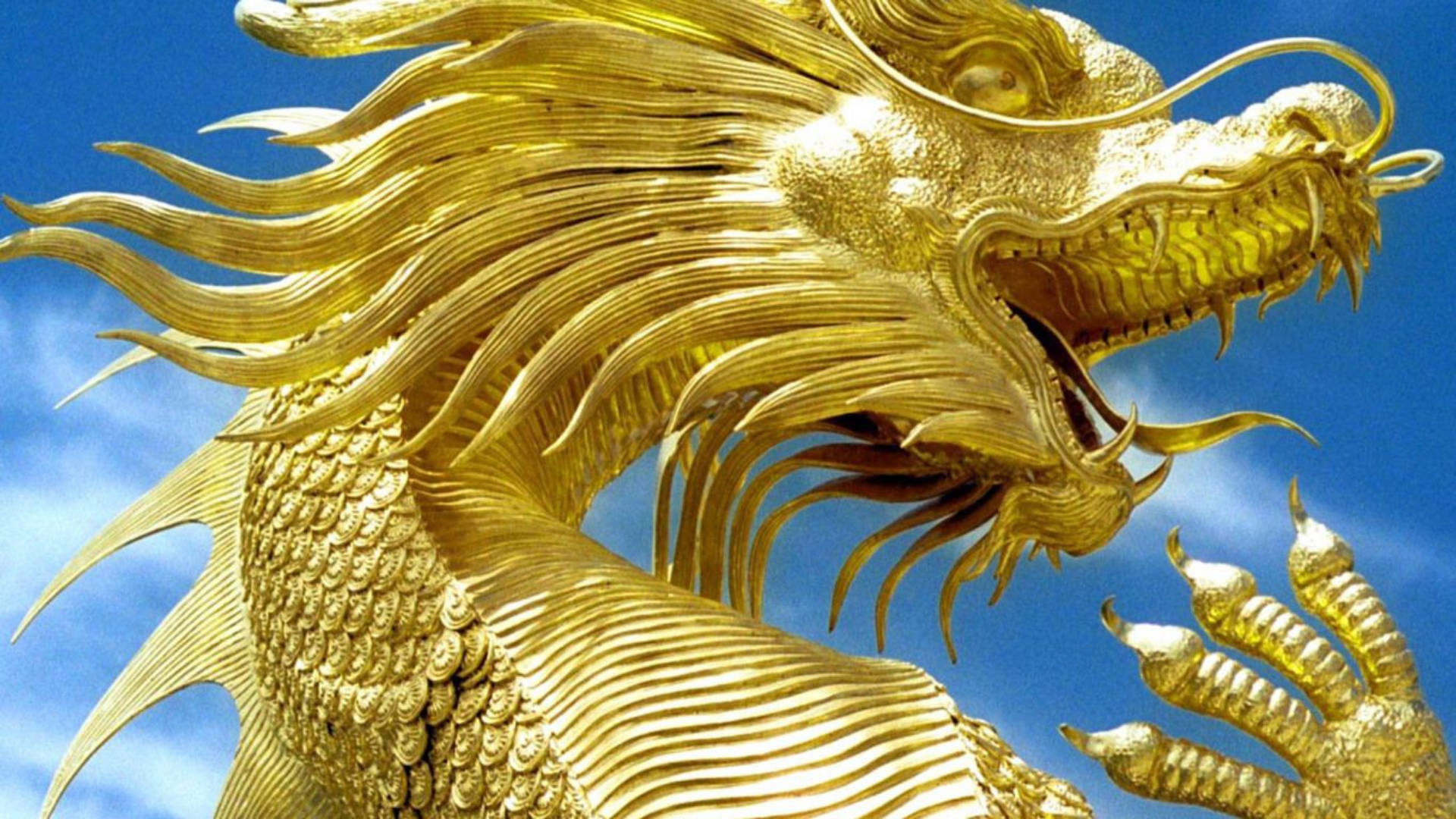 金龍 桌布 壁紙 — 一尊雄偉的金龍雕像，鱗片精緻，鬃毛飄逸，映襯著明亮的藍天。