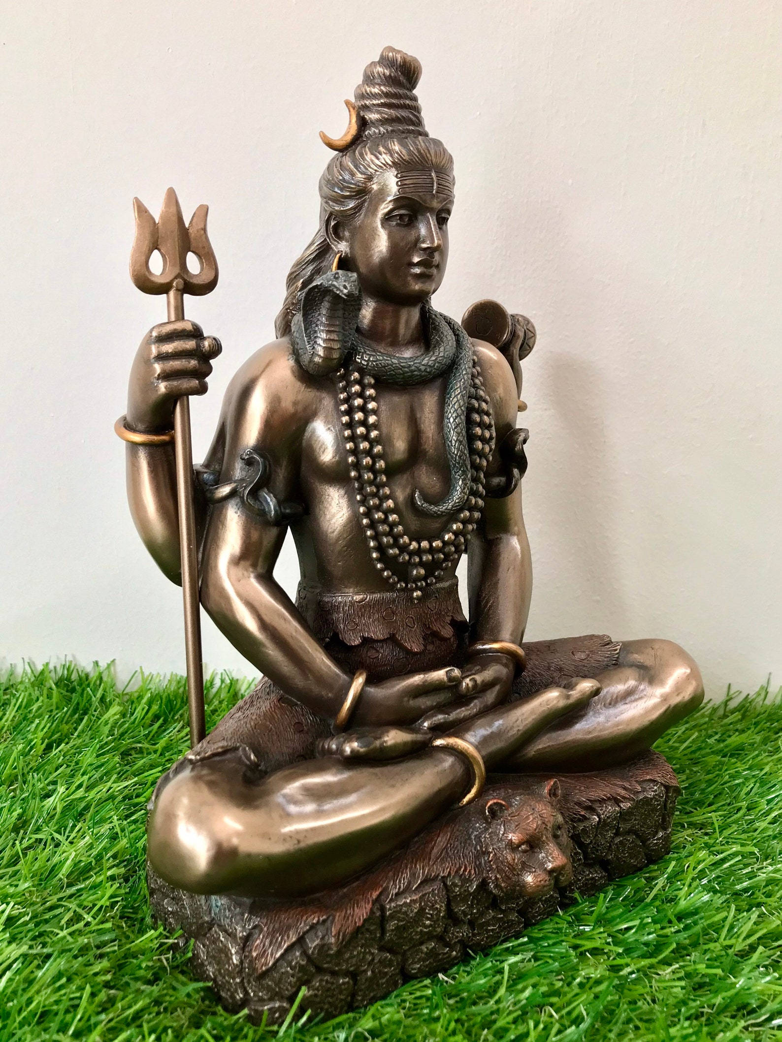 濕婆神 桌布 壁紙 — 一尊青銅雕像，濕婆神盤腿坐在虎頭上，頭髮上有新月，手持三叉戟。