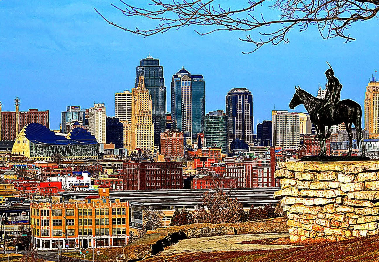 Kansas City 桌布 壁紙 — 一尊青銅騎馬雕像俯瞰著充滿活力的城市景觀，現代摩天大樓和歷史建築在清澈的藍天下交相輝映。