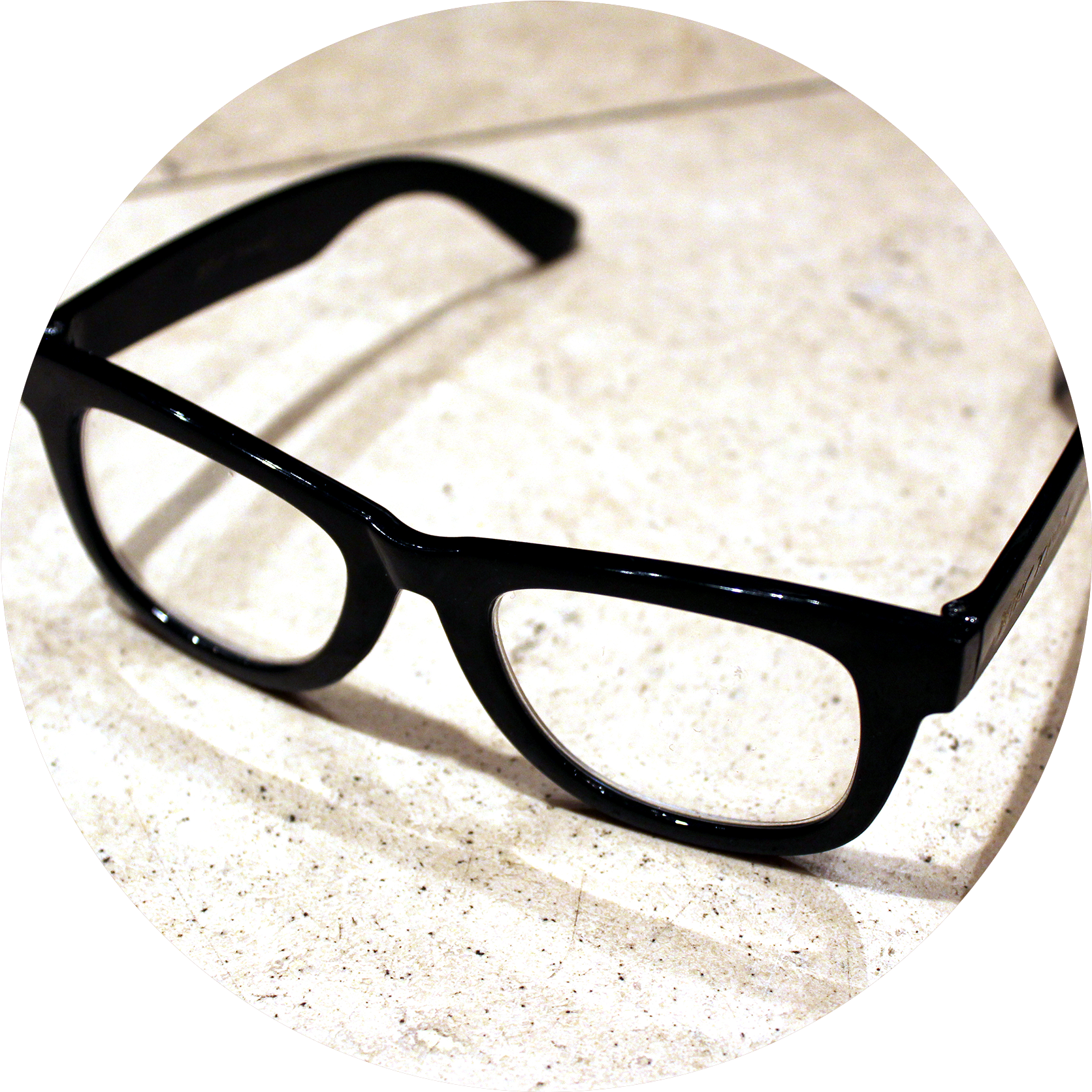 Eyeglasses 桌布 壁紙 — 一對亮面黑色復古眼鏡放置在圓形框架內的斑點米色表面上。