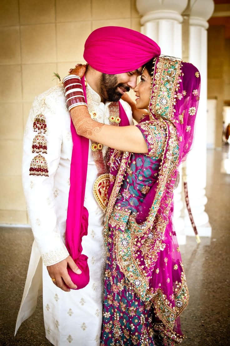 Wedding 桌布 壁紙 — 一對充滿愛意的印度情侶穿著傳統婚禮服飾，在柔和溫暖的燈光下於室內溫柔擁抱。
