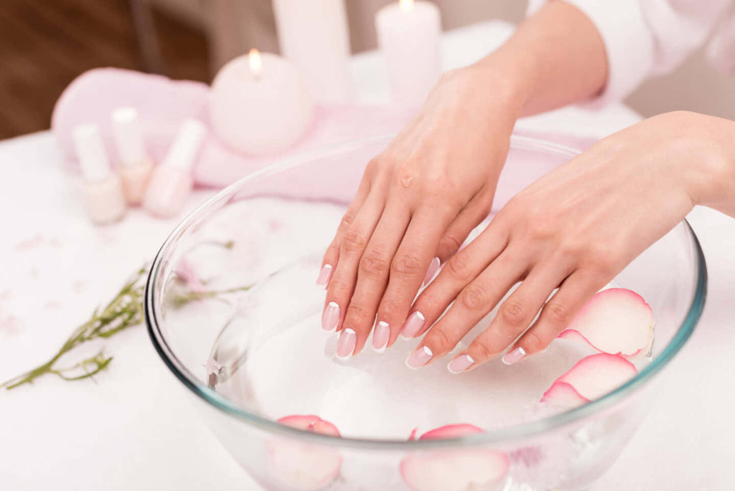 Manicure 桌布 壁紙 — 一對剛修好指甲的手輕輕放在一個玻璃碗的水中，水面上漂浮著粉紅玫瑰花瓣，附近還有點燃的蠟燭。