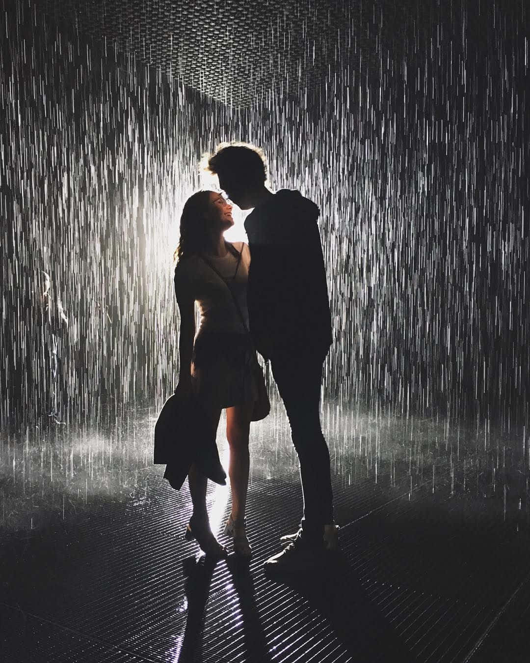 Silhouette 桌布 壁紙 — 一對剪影情侶在戲劇性的室內雨淋花灑下擁抱，帶有背光效果。
