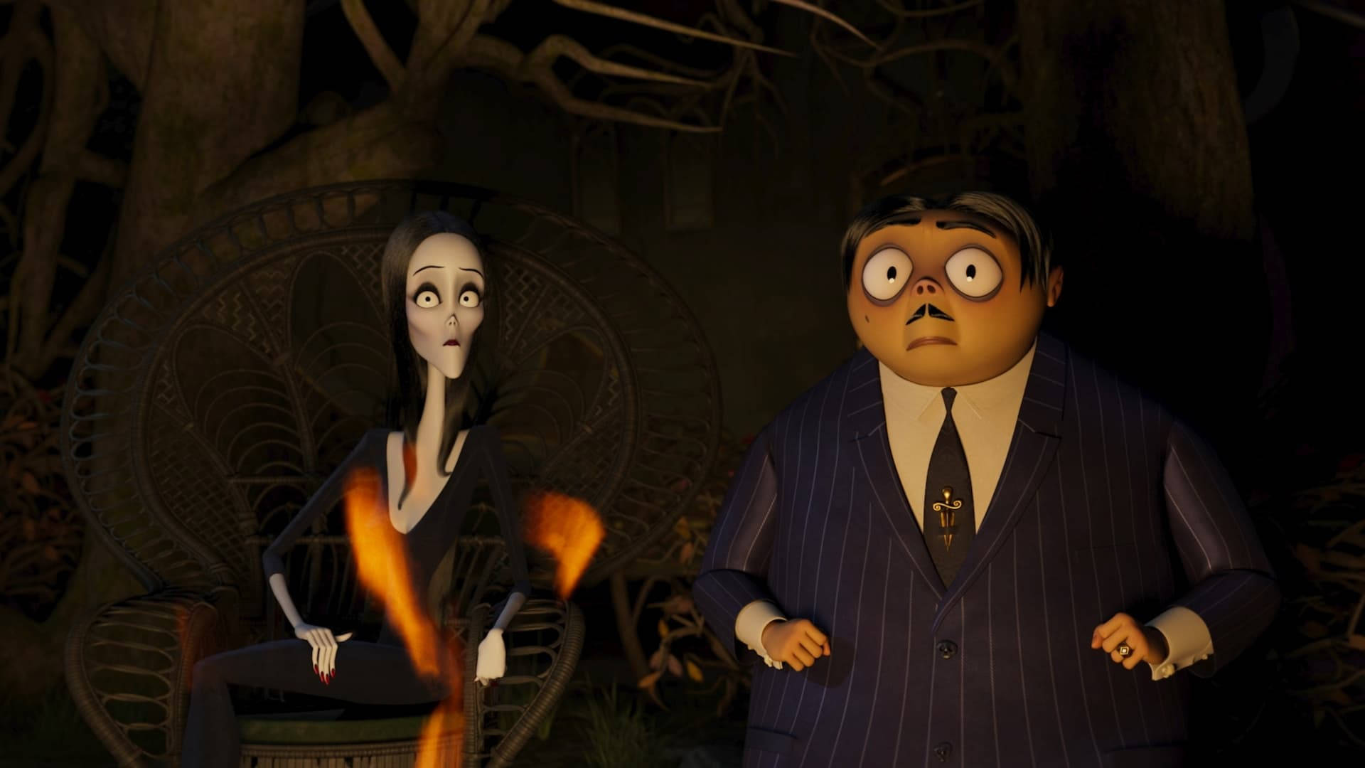 The Addams Family 2 桌布 壁紙 — 一對受驚的動畫情侶在黑暗陰森的花園中，周圍有發光的火焰和扭曲的樹木。