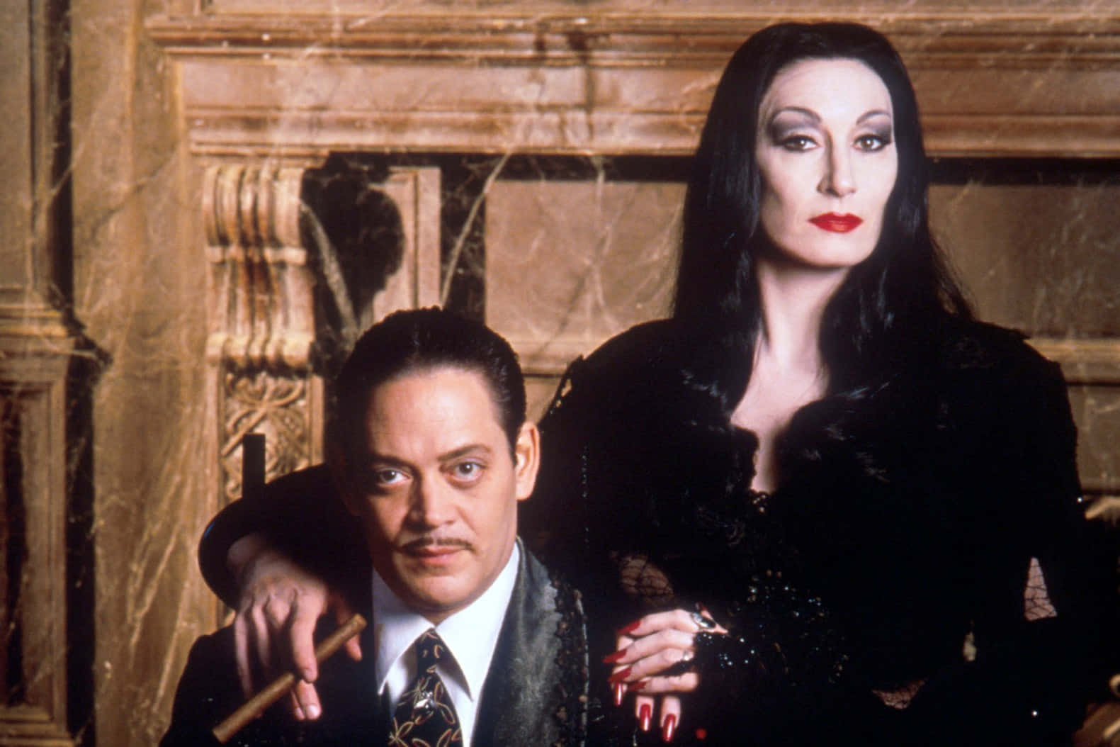 Addams Family 桌布 壁紙 — 一對哥德式情侶在一個華麗、佈滿灰塵的豪宅中優雅地擺姿勢，豪宅內有精緻的木雕和蜘蛛網。