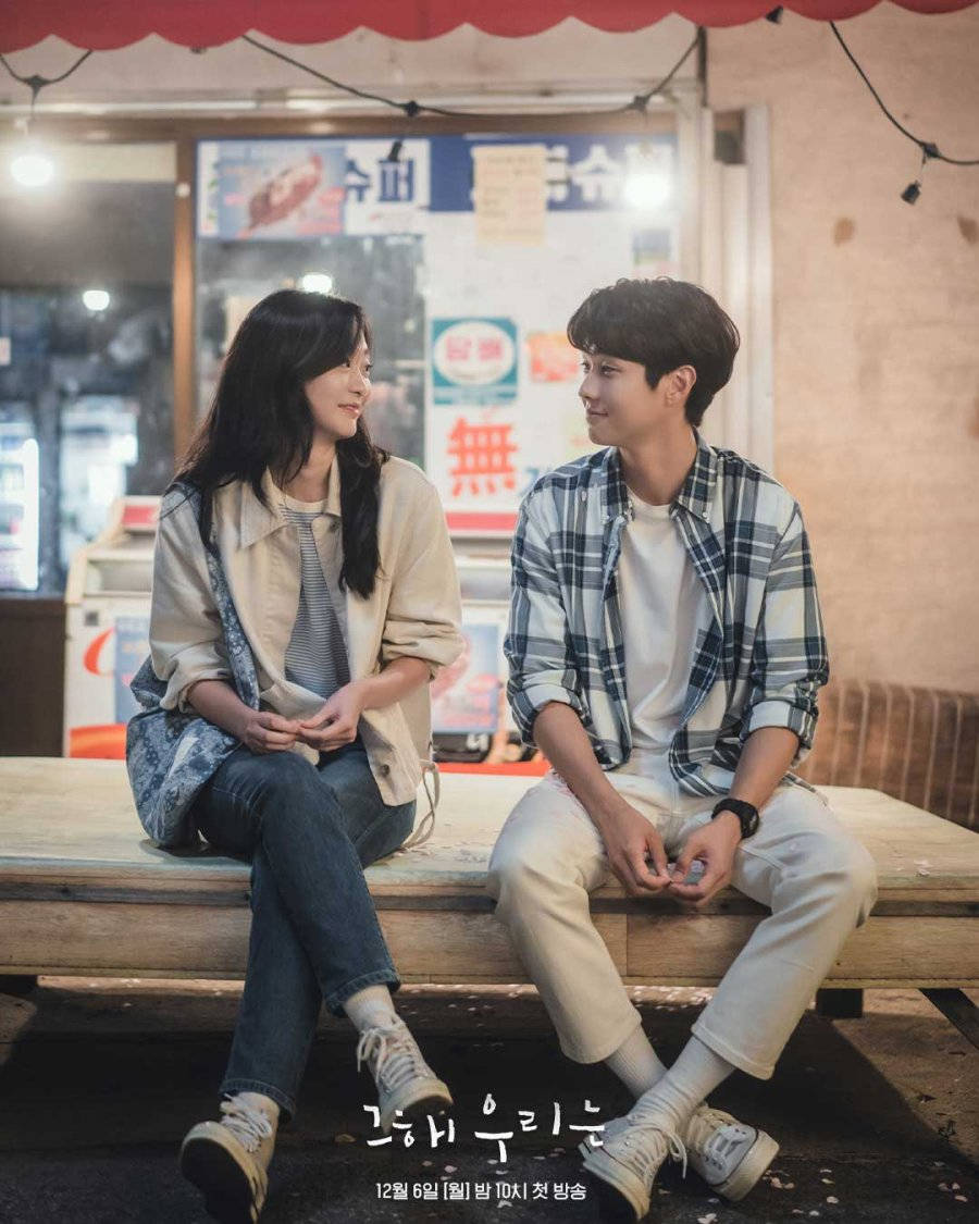 Beloved 桌布 壁紙 — 一對年輕情侶在夜間坐在紅色遮陽篷下的木長椅上，溫暖地微笑著。