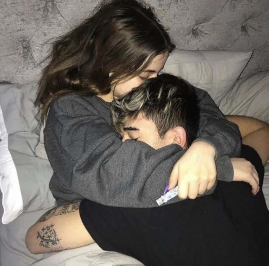 Sleeping 桌布 壁紙 — 一對年輕情侶在帶有紋理灰色床頭板和柔軟白色床單的床上親密擁抱。