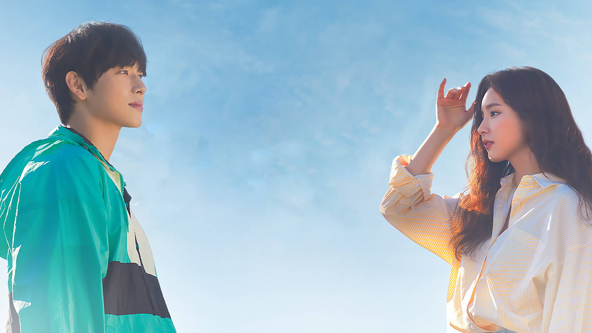kdrama 桌布 壁紙 — 一對年輕情侶在明亮的藍天和柔軟的白雲下深情對望。