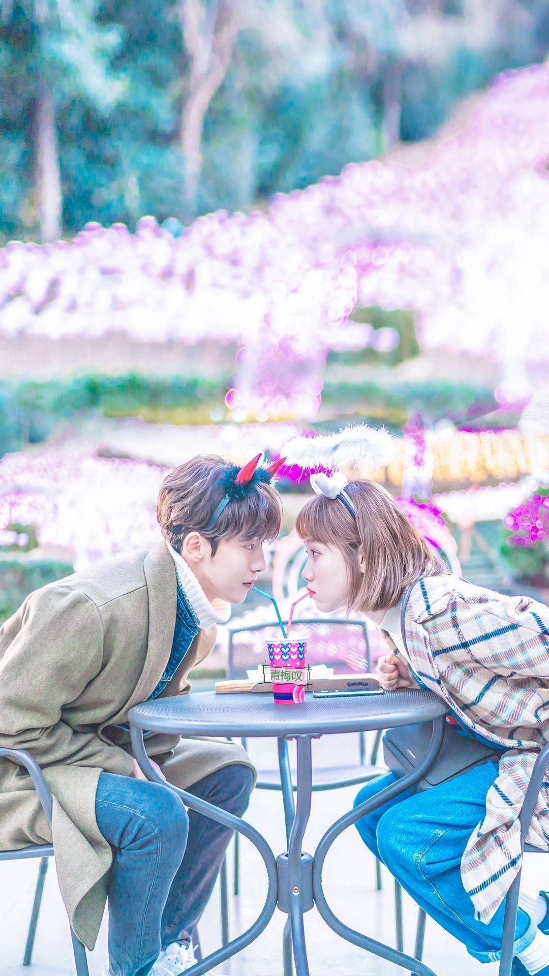 kdrama 桌布 壁紙 — 一對年輕情侶在花園咖啡廳共享甜蜜時光，四周盛開著粉紅色的櫻花。