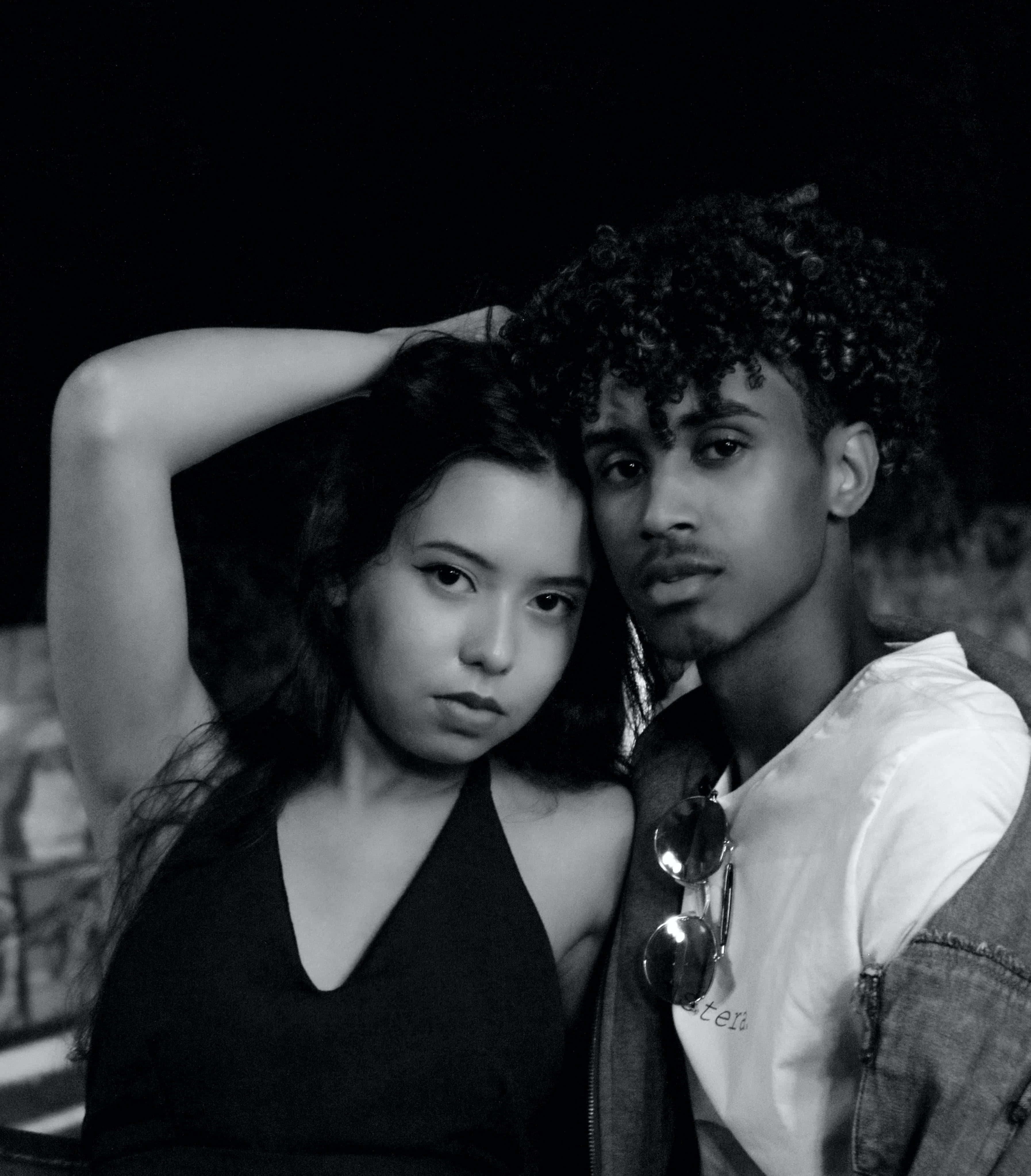 Relationship 桌布 壁紙 — 一對年輕情侶在黑暗背景下親密擺姿勢的黑白肖像，表情嚴肅。
