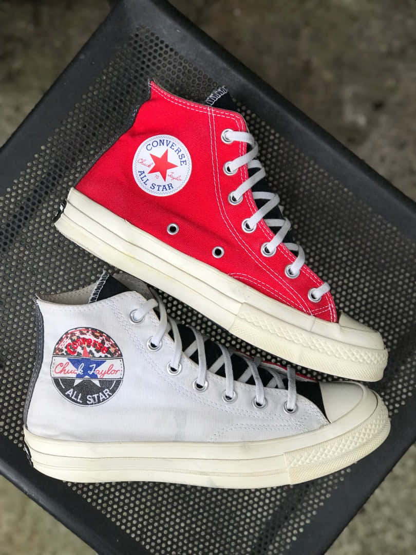 Converse 桌布 壁紙 — 一對復古高筒Converse運動鞋，一紅一白，鞋底磨損，放在黑色穿孔金屬表面上。