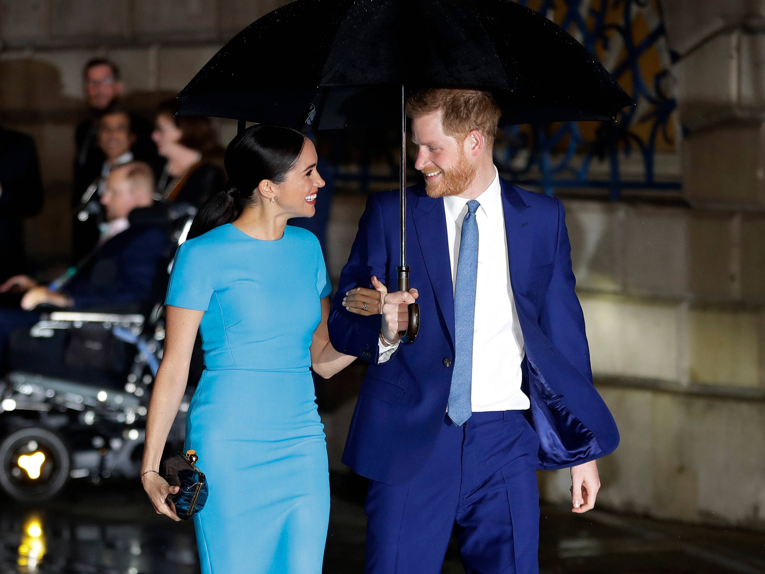 Prince 桌布 壁紙 — 一對微笑的情侶在夜晚撐著黑色雨傘散步，女子身穿藍色連衣裙，男子身穿相配的藍色西裝。