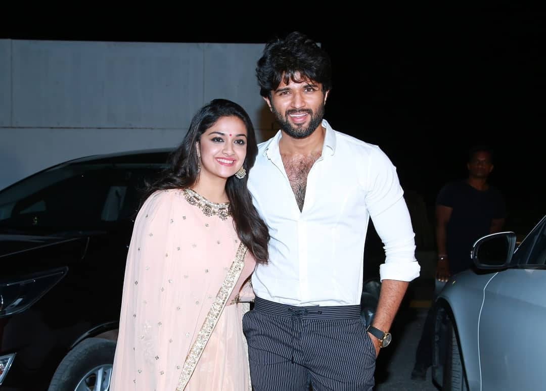 vijay devarakonda 4K 桌布 壁紙 — 一對微笑的情侶在夜間於人造燈光下，在停泊的汽車旁一起擺姿勢。