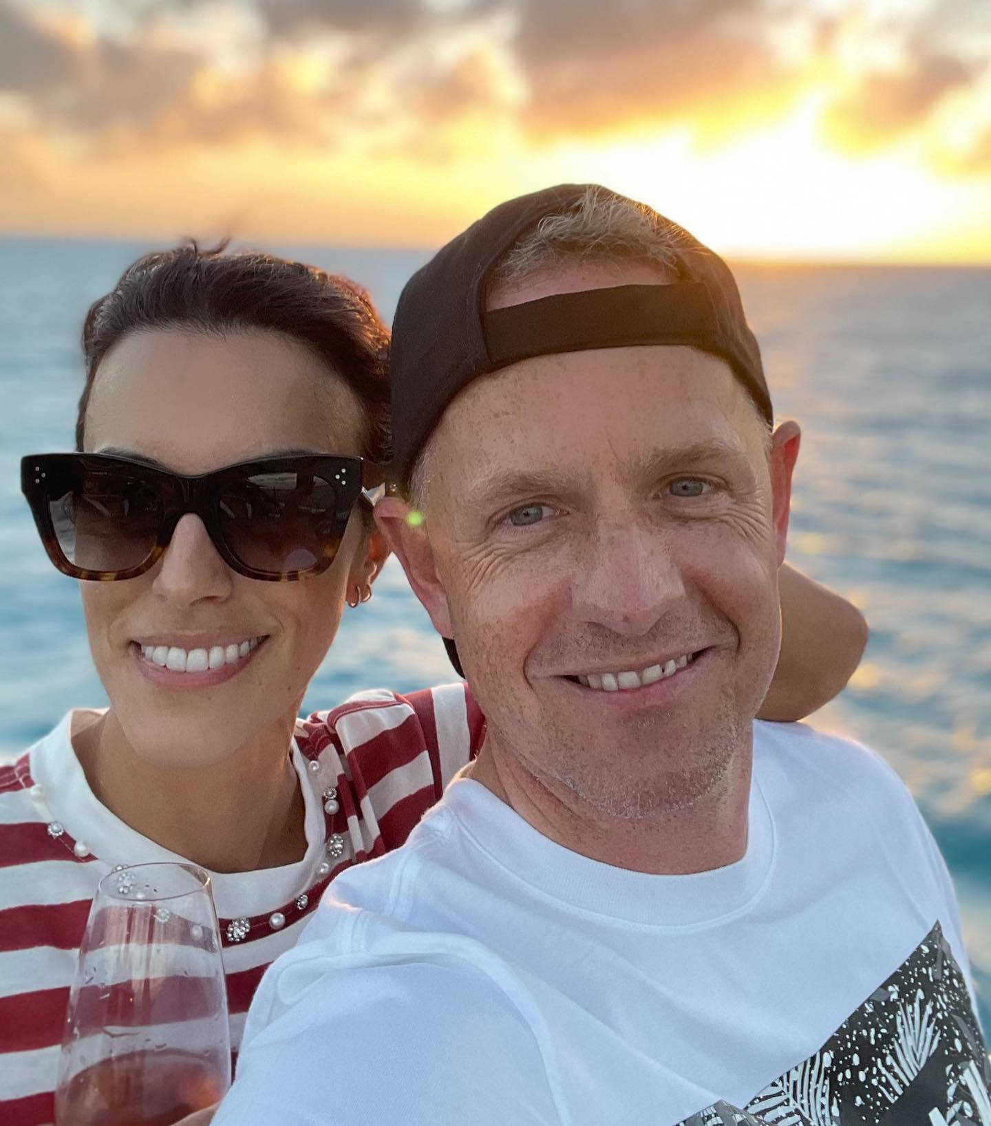 Wife 桌布 壁紙 — 一對微笑的情侶在日落時分以海洋為背景，手持酒杯自拍。