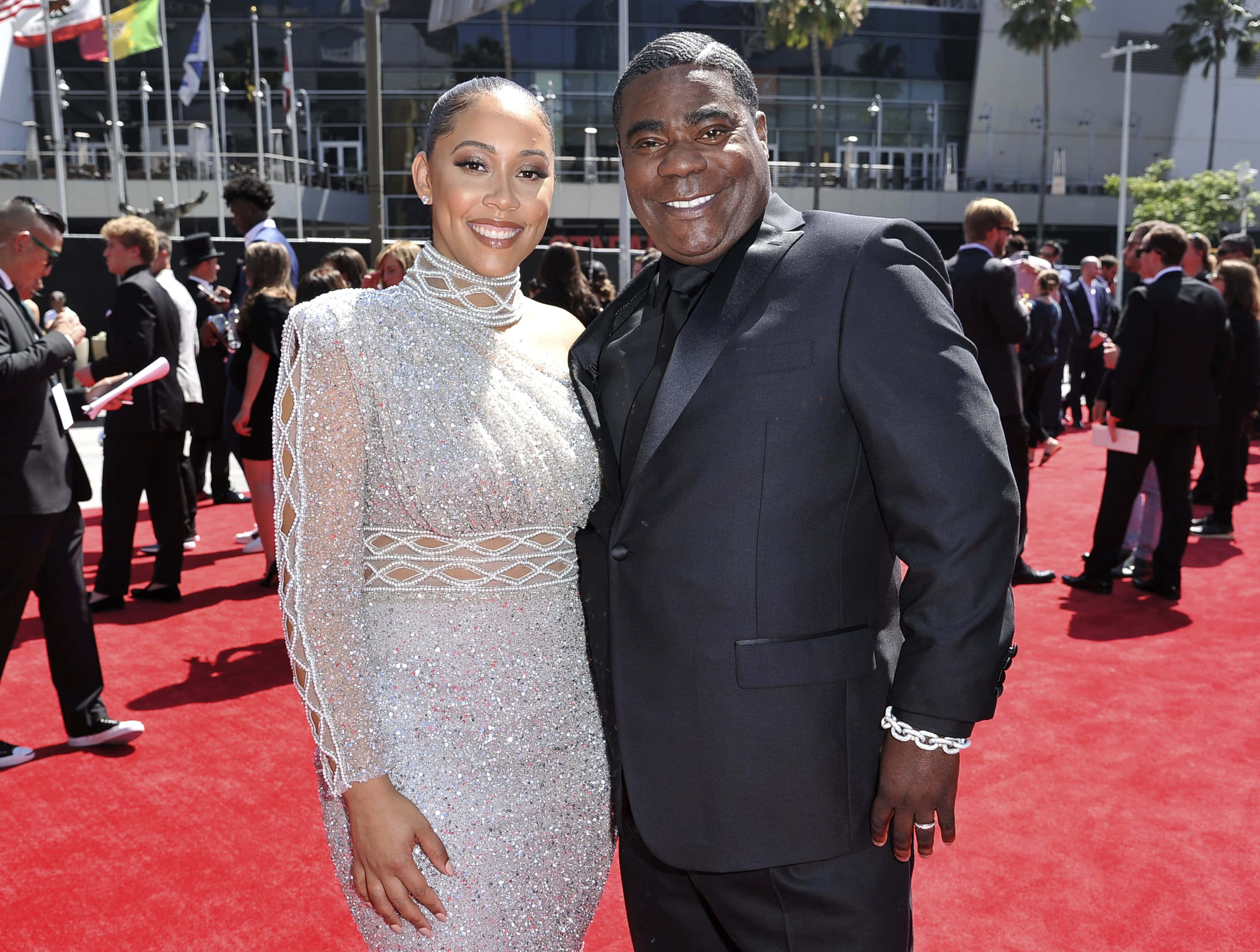 Tracy Morgan 桌布 壁紙 — 一對微笑的情侶在明亮的日光下，於一個迷人的戶外活動中，在鮮紅的地毯上擺姿勢。
