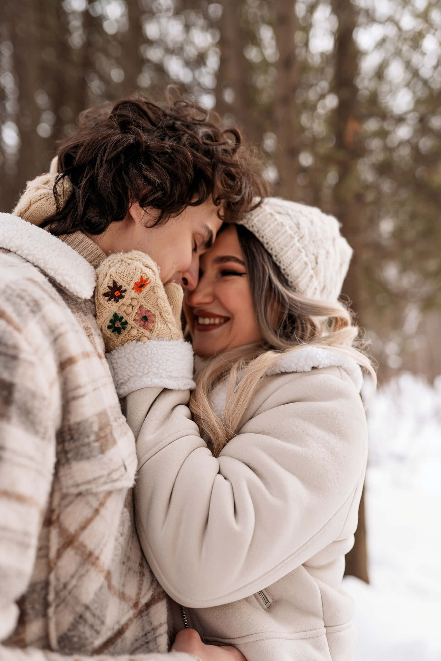 Boyfriend And Girlfriend 桌布 壁紙 — 一對微笑的情侶在雪地森林中穿著舒適的冬季外套和針織帽溫暖擁抱。
