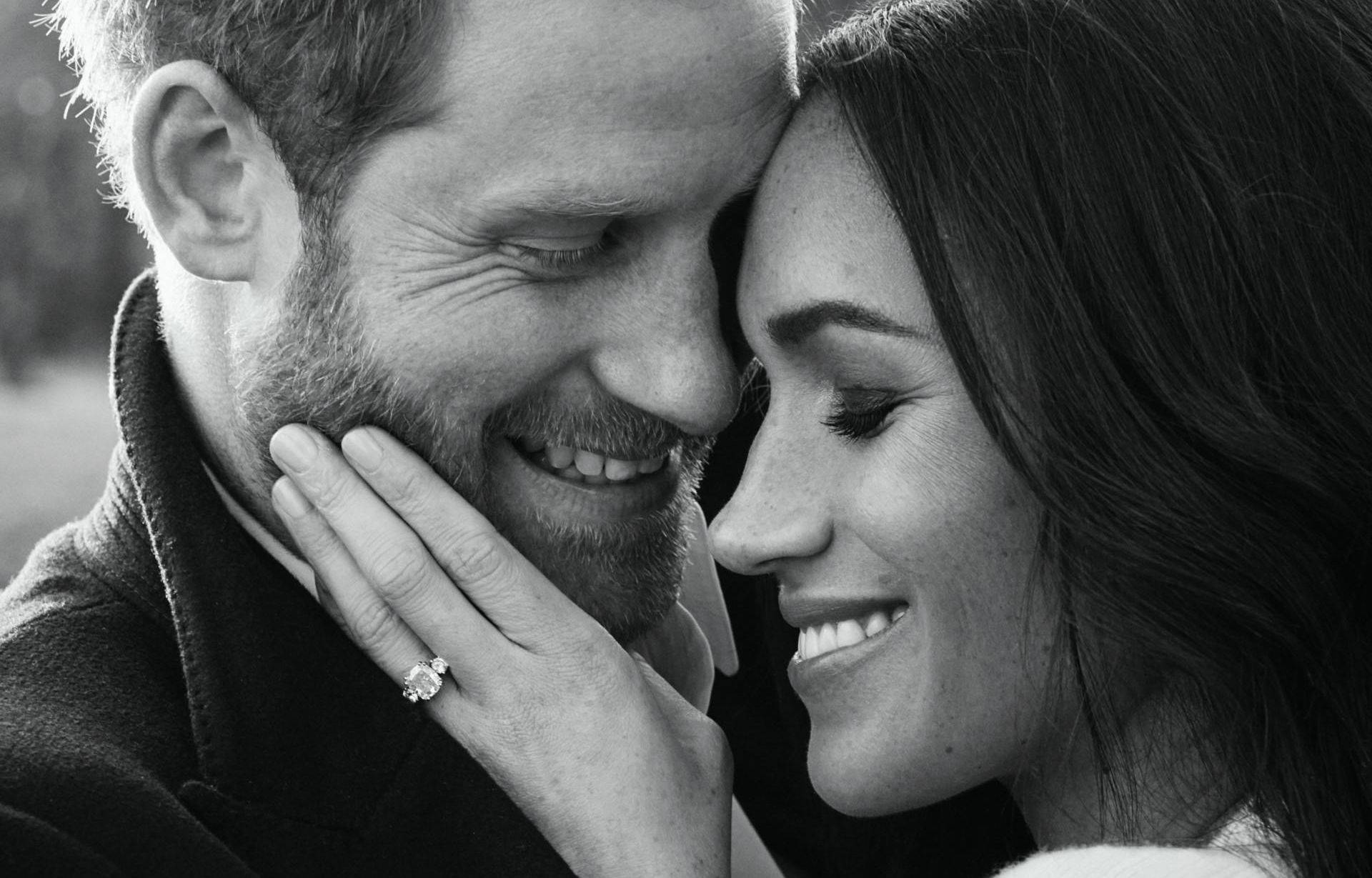 Meghan Markle 桌布 壁紙 — 一對微笑的情侶溫柔地額頭相觸，閃耀的訂婚戒指清晰可見的黑白親密肖像。