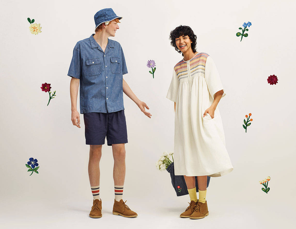 Uniqlo 桌布 壁紙 — 一對微笑的情侶穿著休閒夏裝，站在以彩色刺繡花朵裝飾的白色背景前。