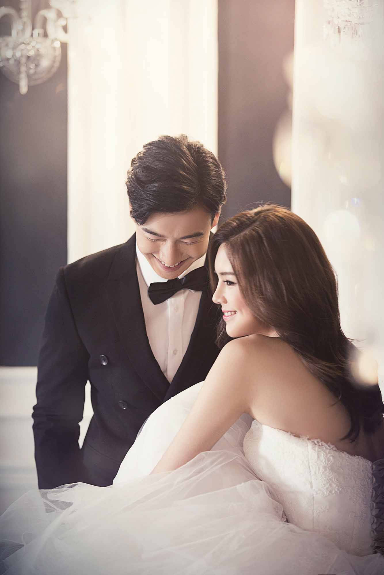 Couples 桌布 壁紙 — 一對微笑的新人穿著婚紗禮服，在柔和燈光的優雅室內環境中分享親密時刻。