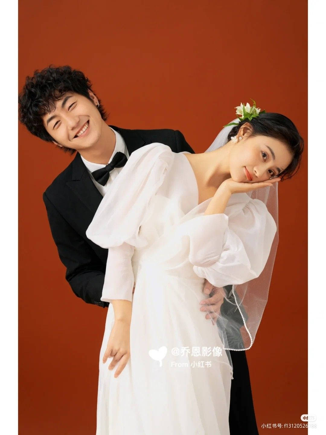 Couples 桌布 壁紙 — 一對微笑的新人穿著婚紗禮服，在溫暖的陶土色工作室背景前親密擺姿勢。