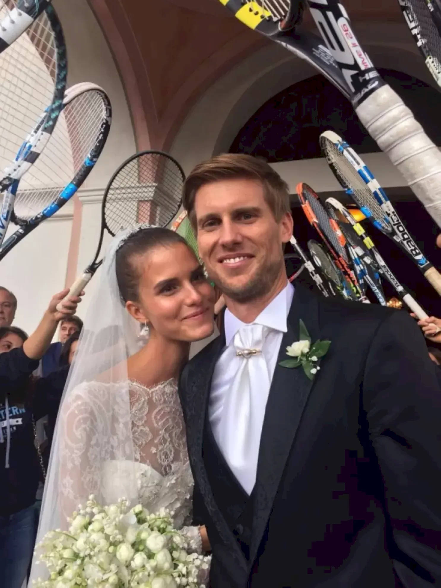 Wedding 桌布 壁紙 — 一對微笑的新郎新娘在婚禮上被賓客手持的網球拍包圍著拍照。