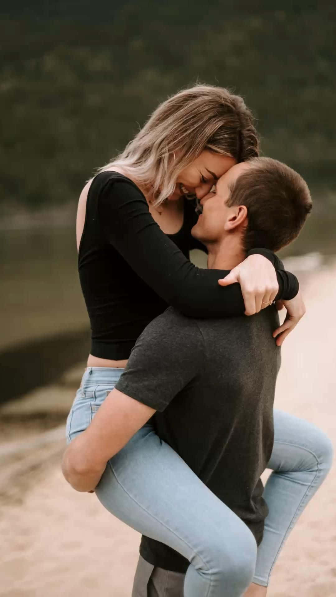 Hugging 桌布 壁紙 — 一對快樂的情侶在寧靜的自然環境中親吻，女方調皮地騎在男方背上。