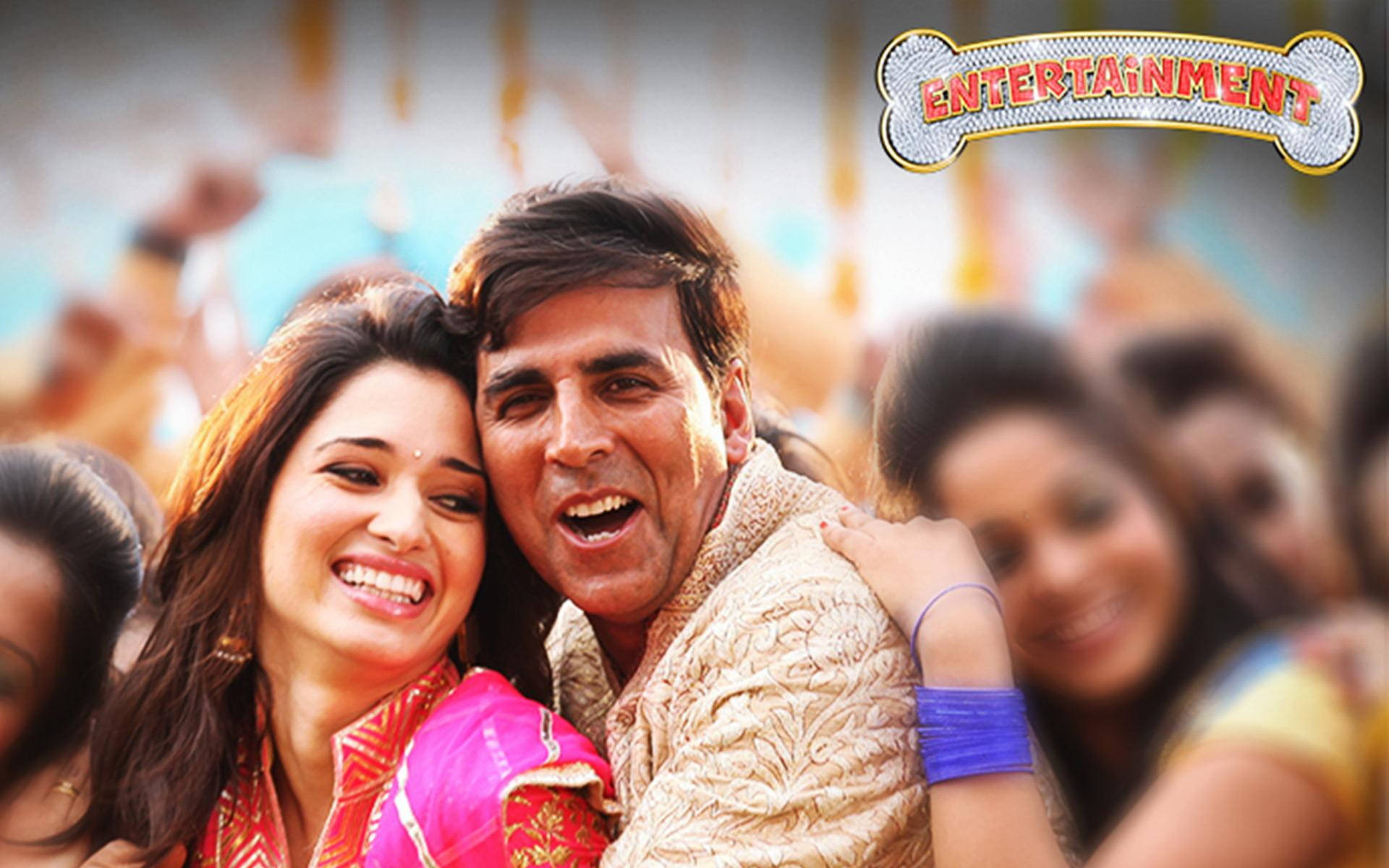 Akshay Kumar 桌布 壁紙 — 一對快樂的情侶在明亮的日光下，在節慶的人群中擁抱和歡笑。