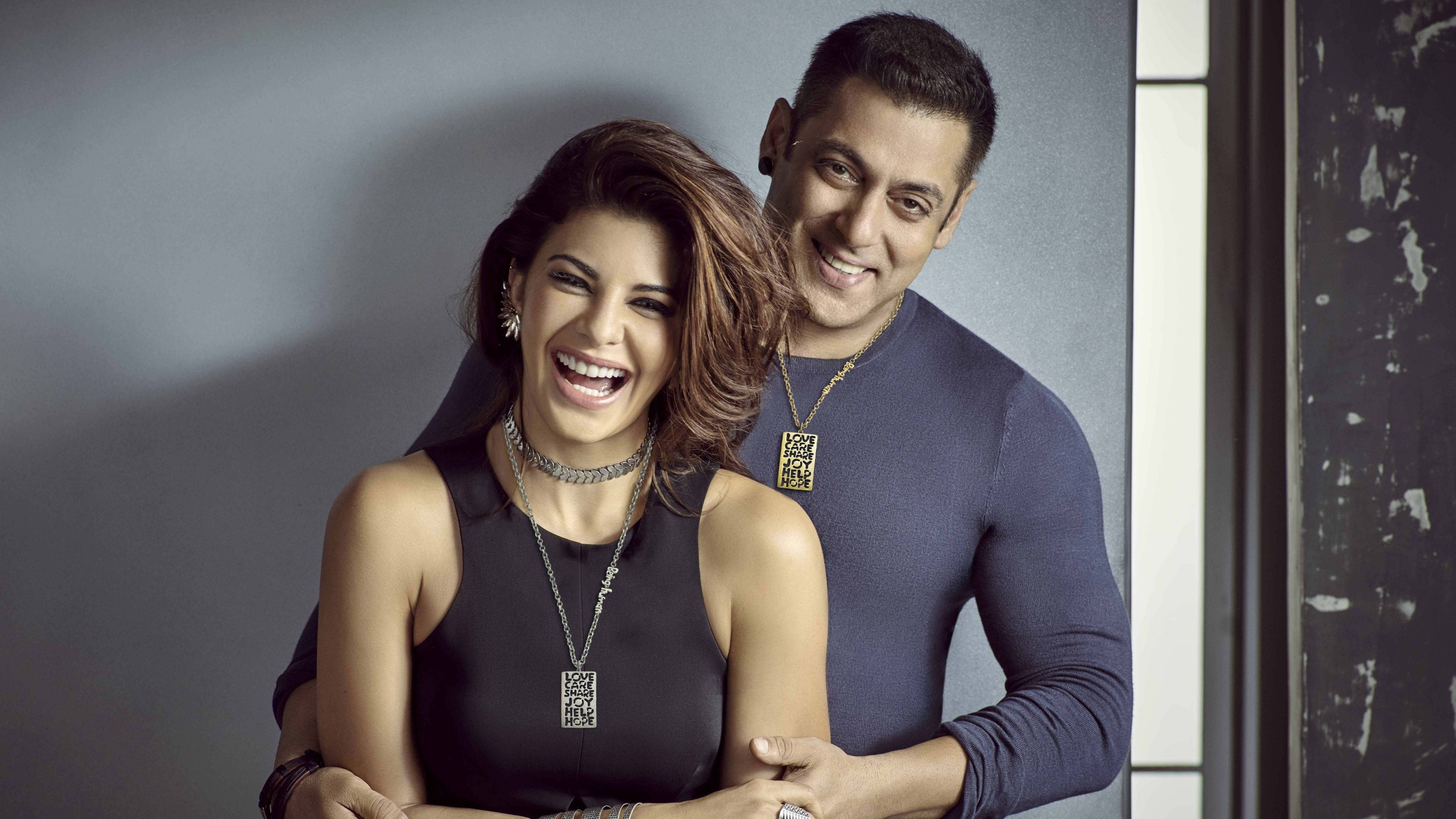 salman khan HD 桌布 壁紙 — 一對快樂的情侶在時尚的工作室肖像中一起大笑，背景是戲劇性的燈光和紋理灰色牆壁。