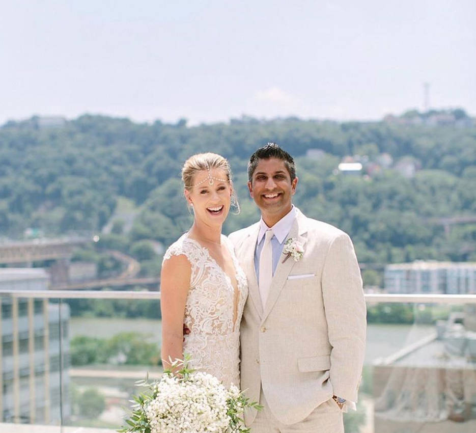 Wedding 桌布 壁紙 — 一對快樂的新娘和新郎在陽光明媚的屋頂上微笑，俯瞰著鬱鬱蔥蔥的綠色山谷和河流。